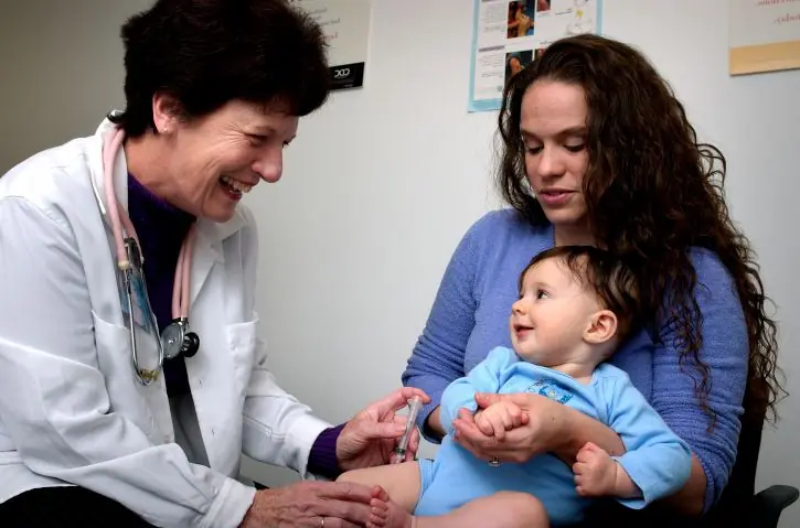 infant-being-held-by-his-mother-while-receiving-vaccination